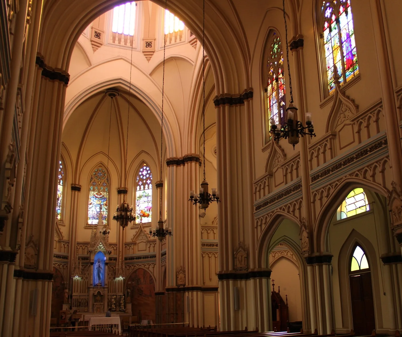 Nave interior da Basílica de Lourdes com vitrais coloridos